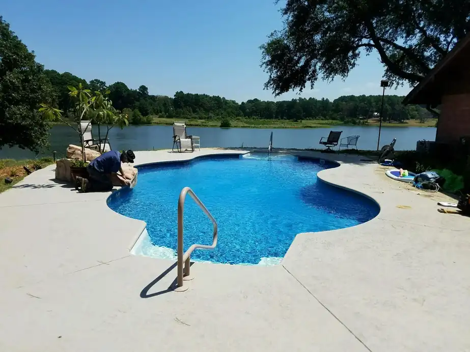 A free-form liner pool on a lake edge, the water clear to the floor