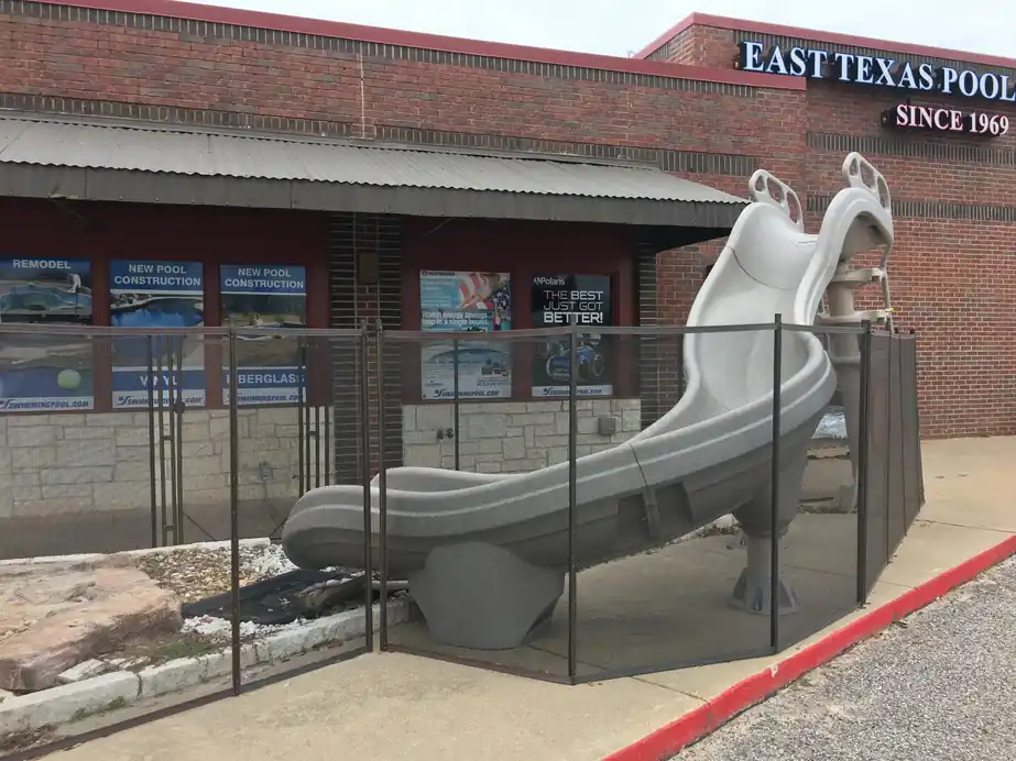 The brick storefront with its display slide behind a mesh safety fence